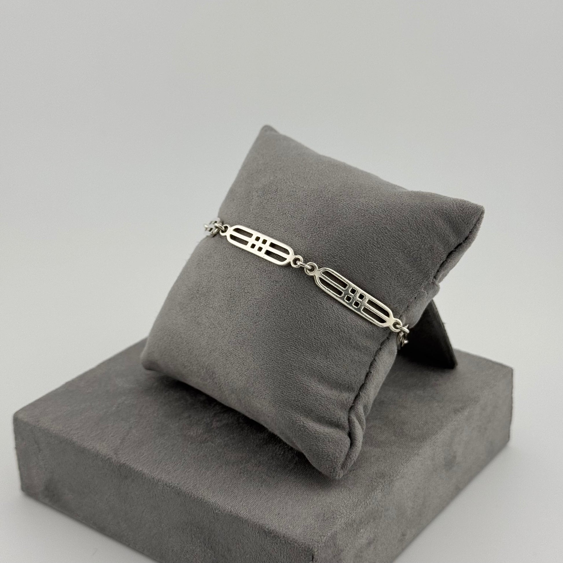 sterling silver geometric bracelet on a grey cushion