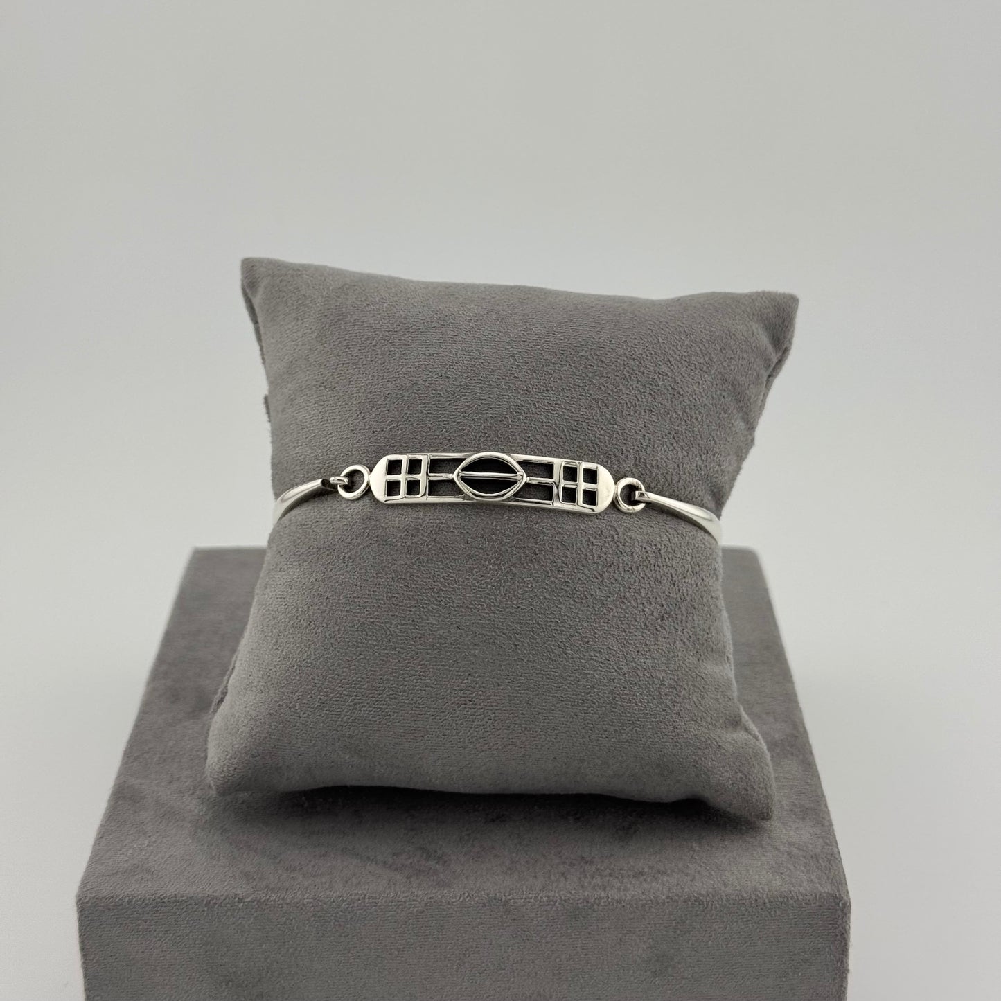 sterling silver kit heath bracelet displayed on a suede grey cushion