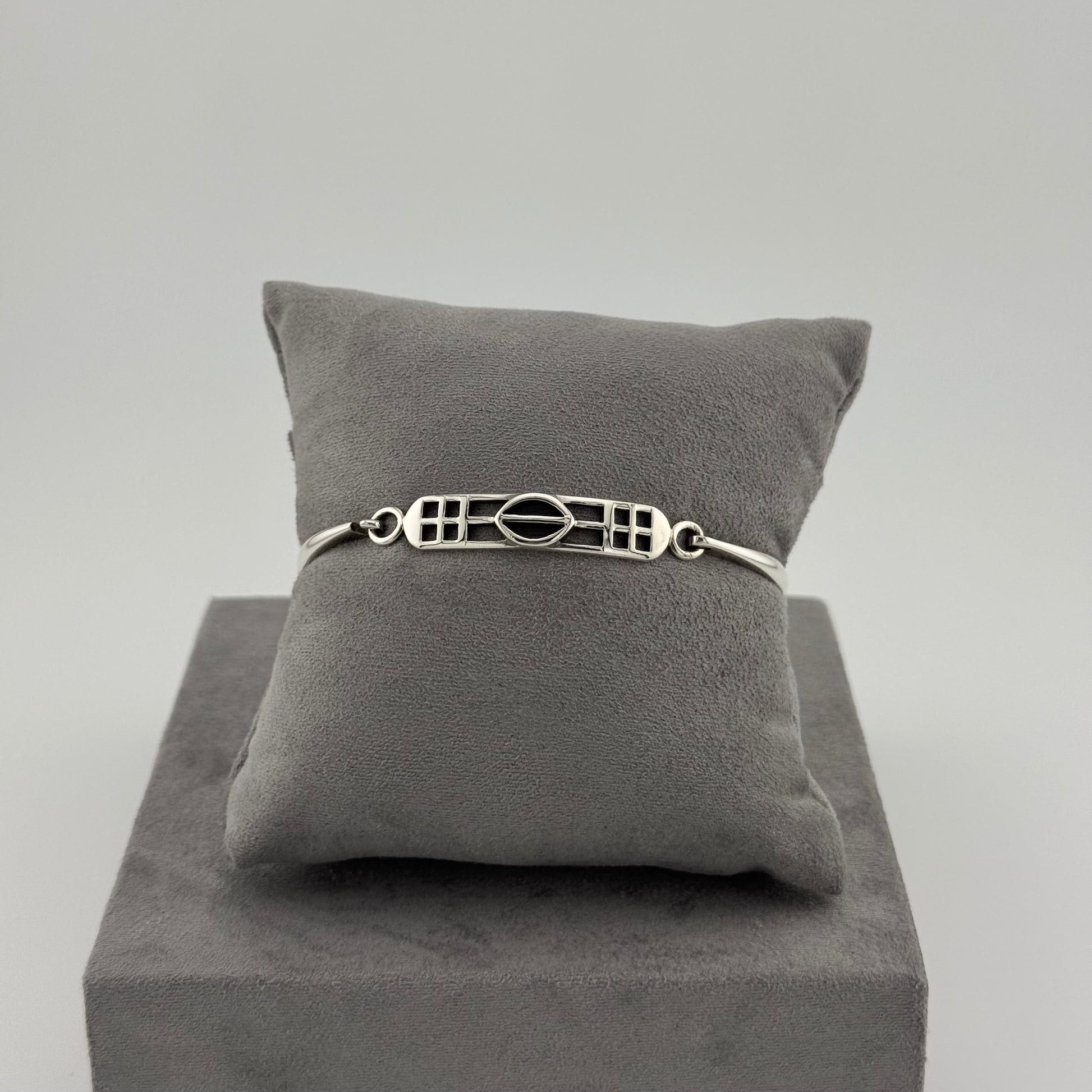 sterling silver kit heath bracelet displayed on a suede grey cushion