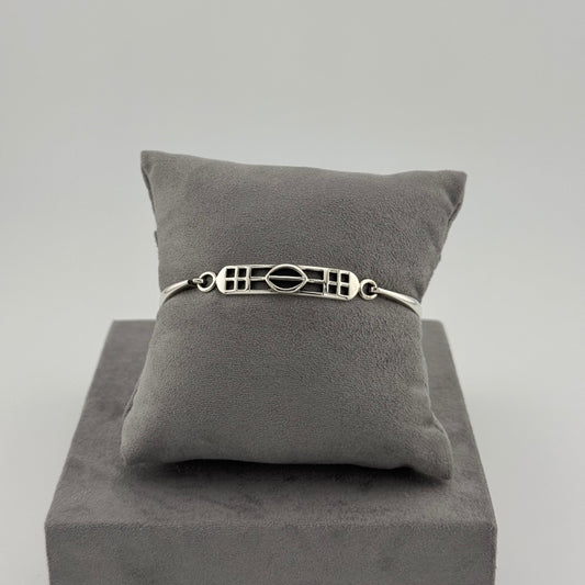 sterling silver kit heath bracelet displayed on a suede grey cushion