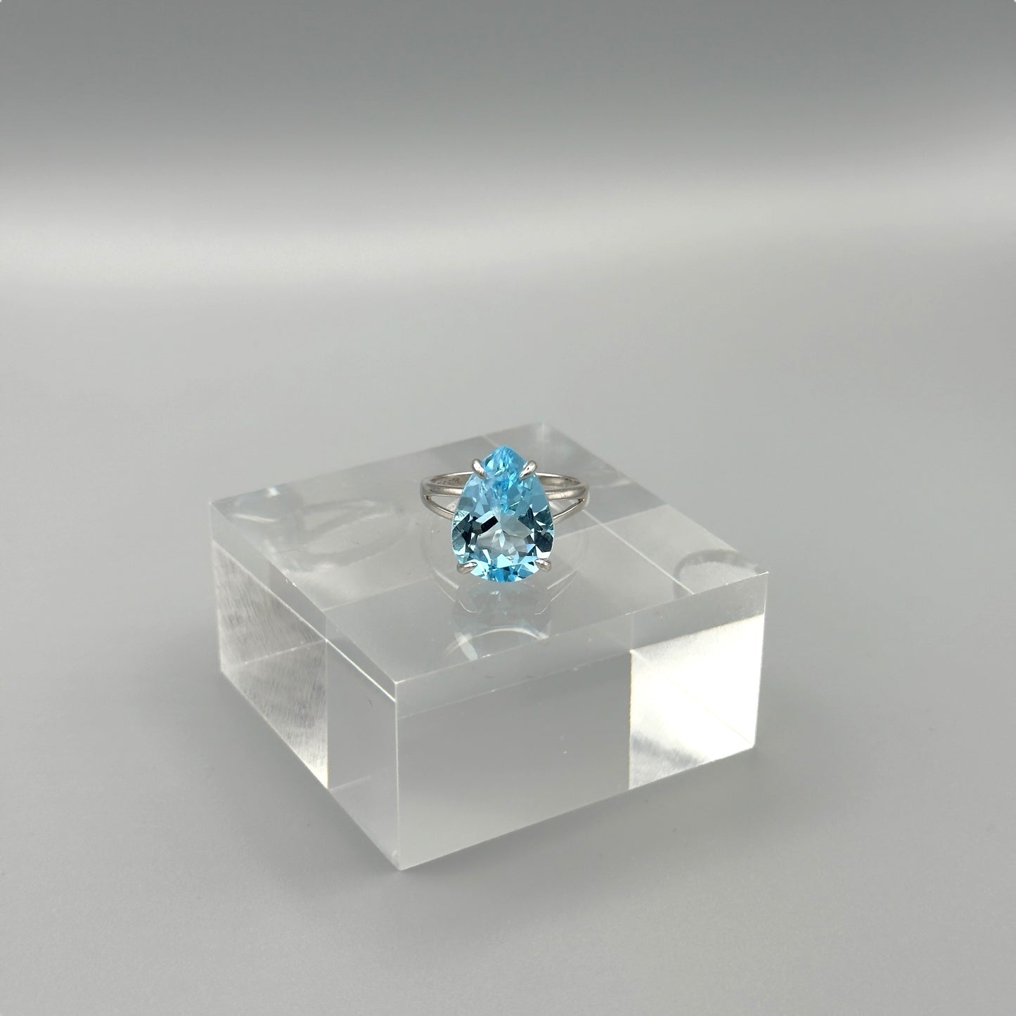 Sterling silver ring with pear-cut aquamarine on acrylic block