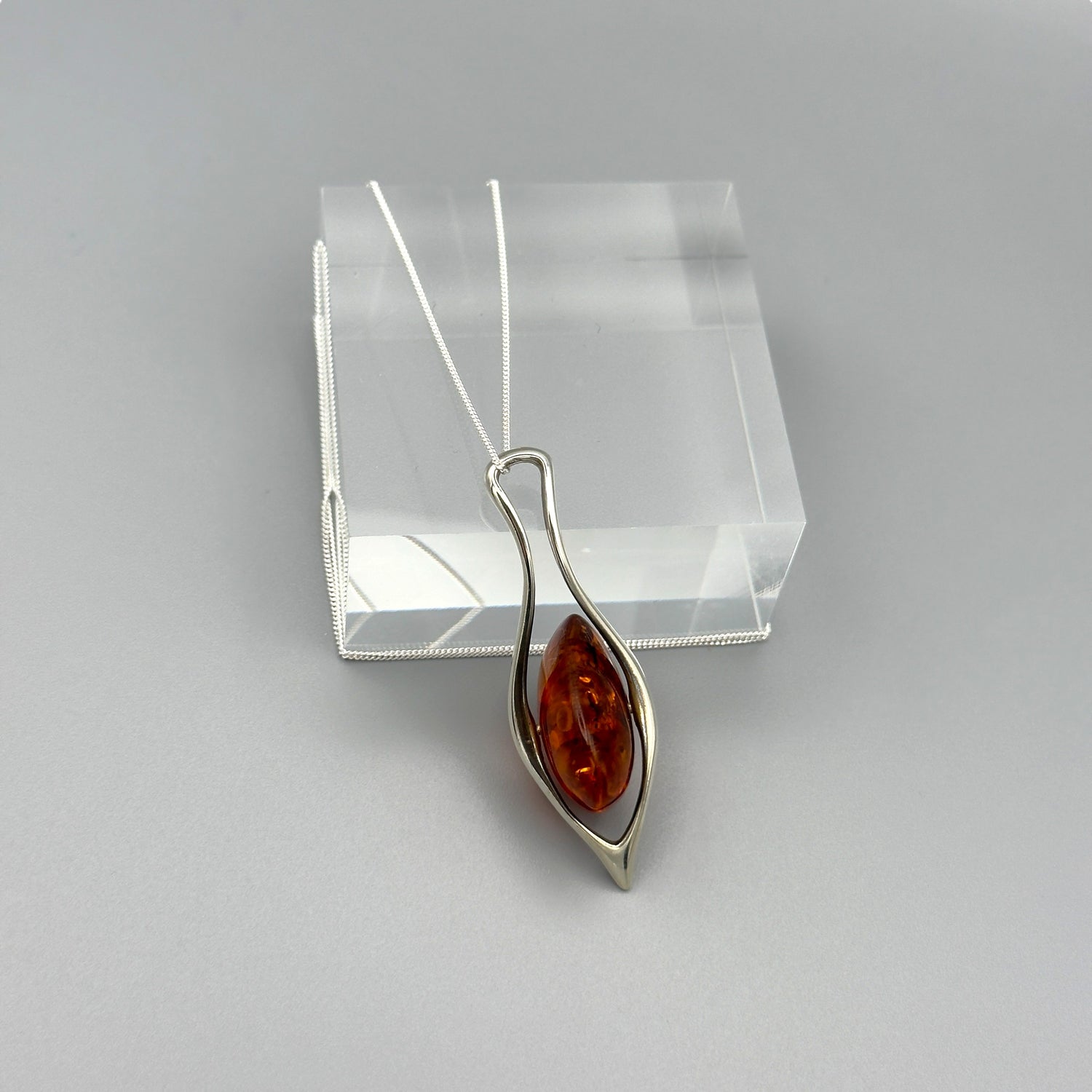 Freeform amber pendant necklace in silver twisted frame

