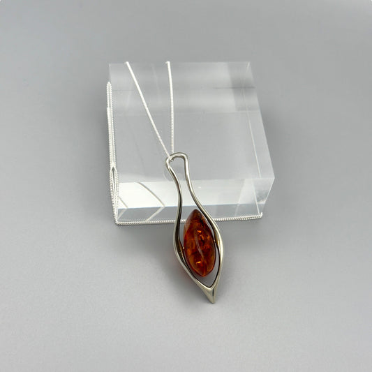 Freeform amber pendant necklace in silver twisted frame

