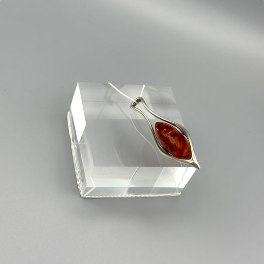 Amber stone pendant with flowing silver design