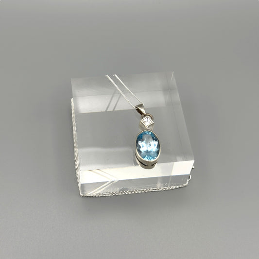 Close-up of aquamarine oval pendant on silver chain