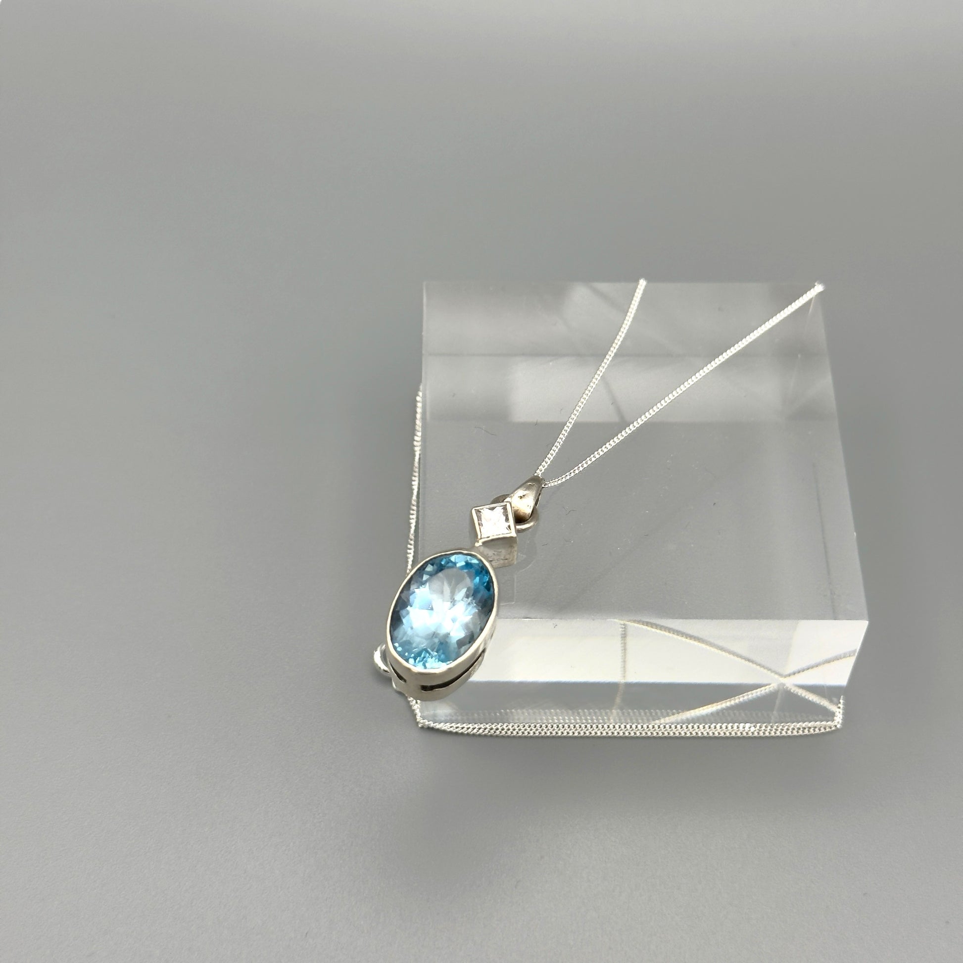 Light blue aquamarine necklace displayed on clear block