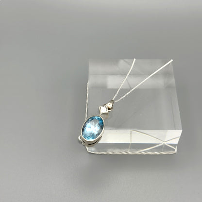 Light blue aquamarine necklace displayed on clear block