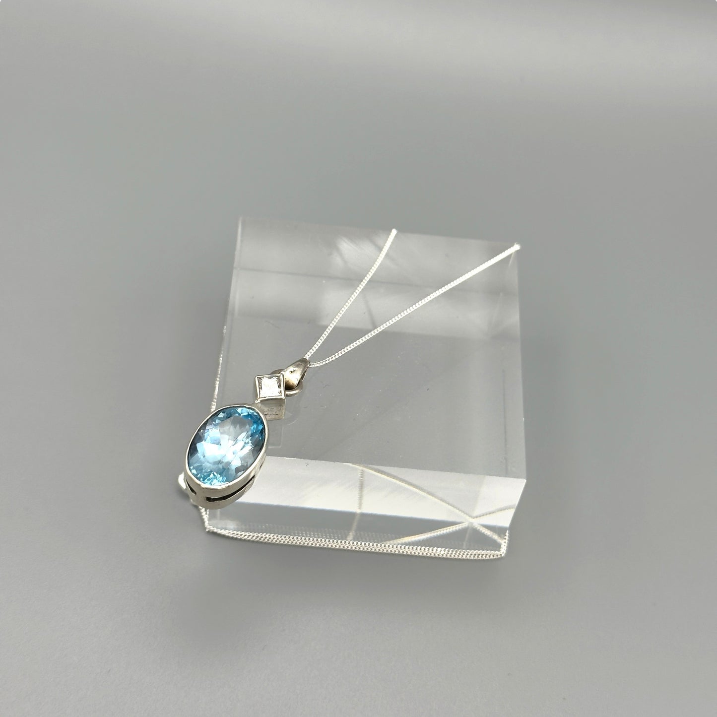Aquamarine and silver pendant necklace photographed flat