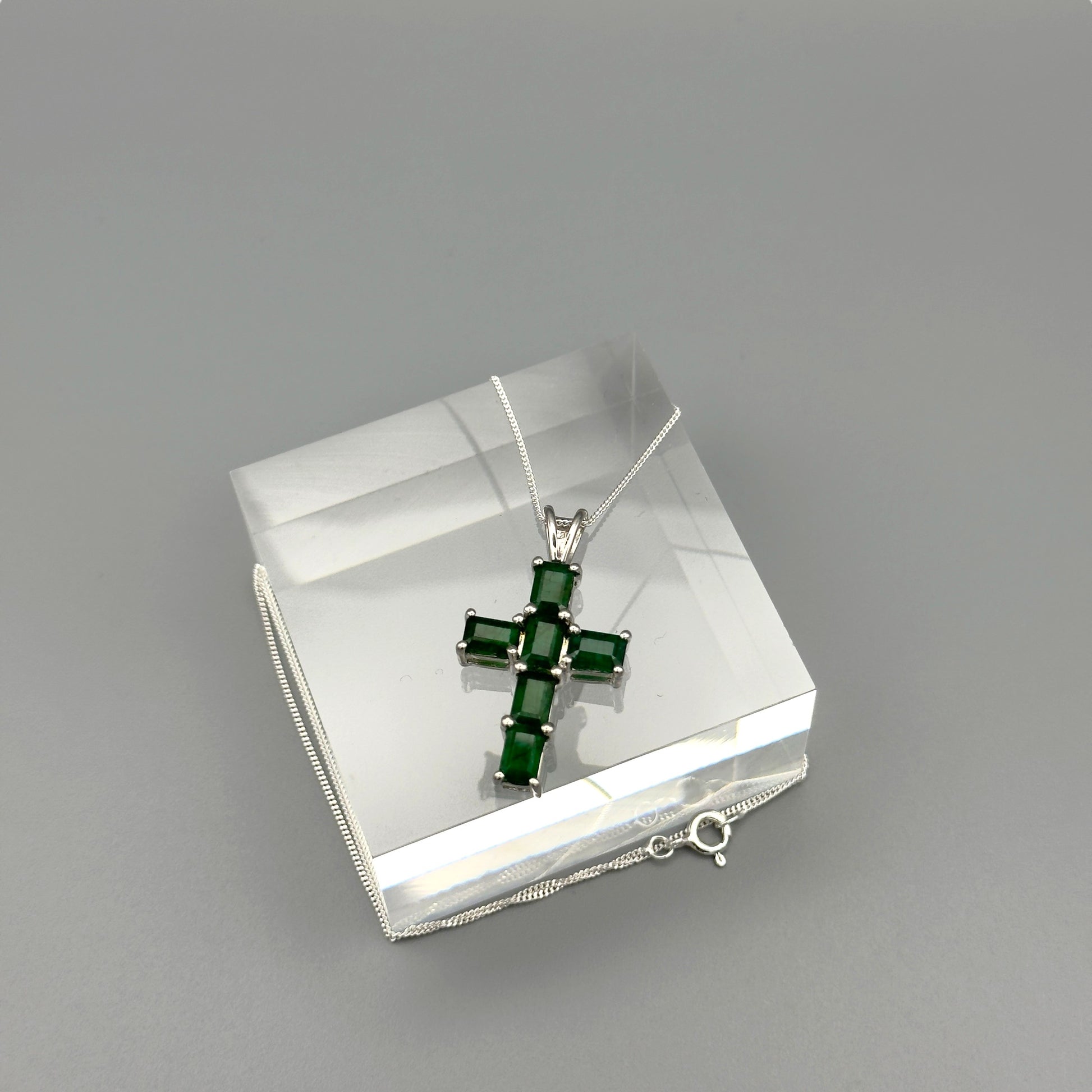 Overhead photo of sterling silver emerald cross necklace with clasp