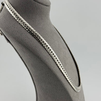 Herringbone chain in sterling silver weighing 50g sat on a grey suede bust