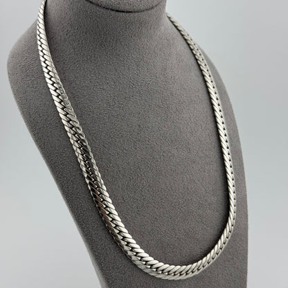Herringbone chain in sterling silver weighing 50g sat on a grey suede bust