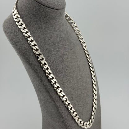 Silver chain necklace on a mannequin bust against a gray background
