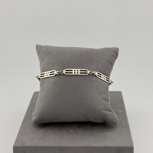 sterling silver geometric bracelet on a grey cushion