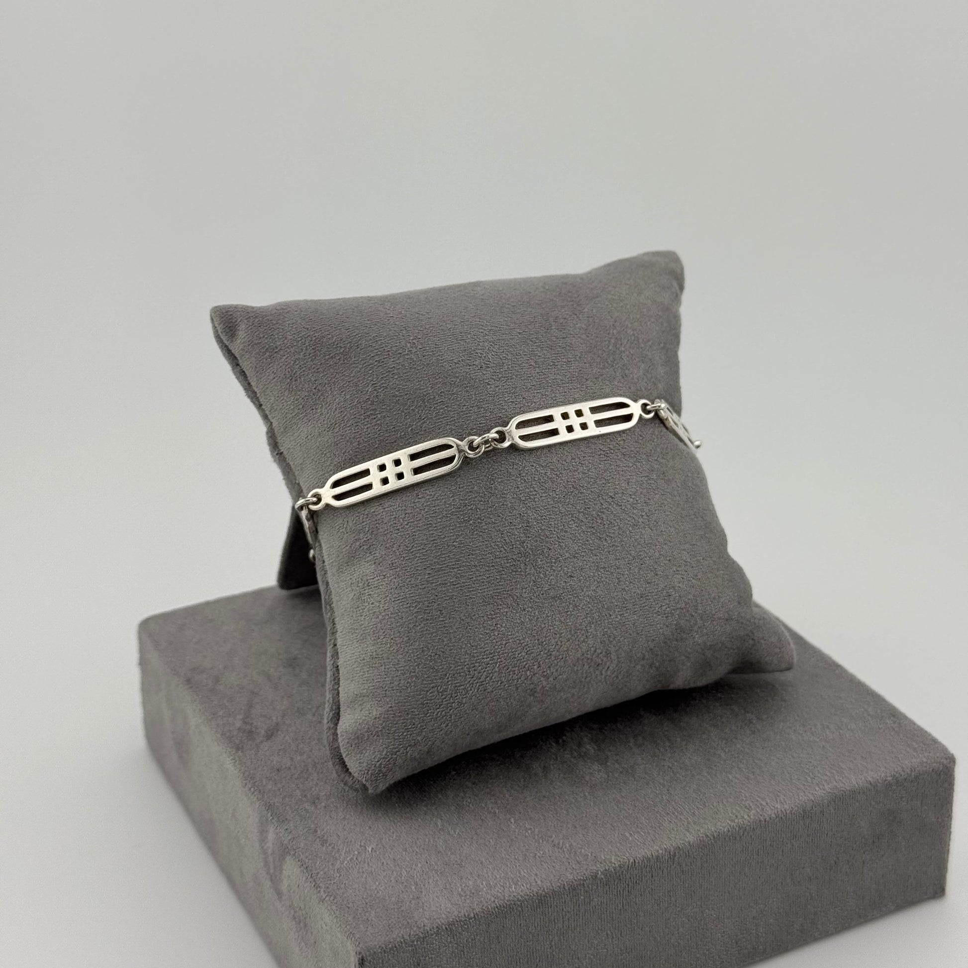 sterling silver geometric bracelet on a grey cushion