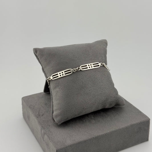sterling silver geometric bracelet on a grey cushion