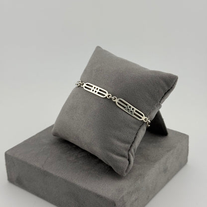 sterling silver geometric bracelet on a grey cushion