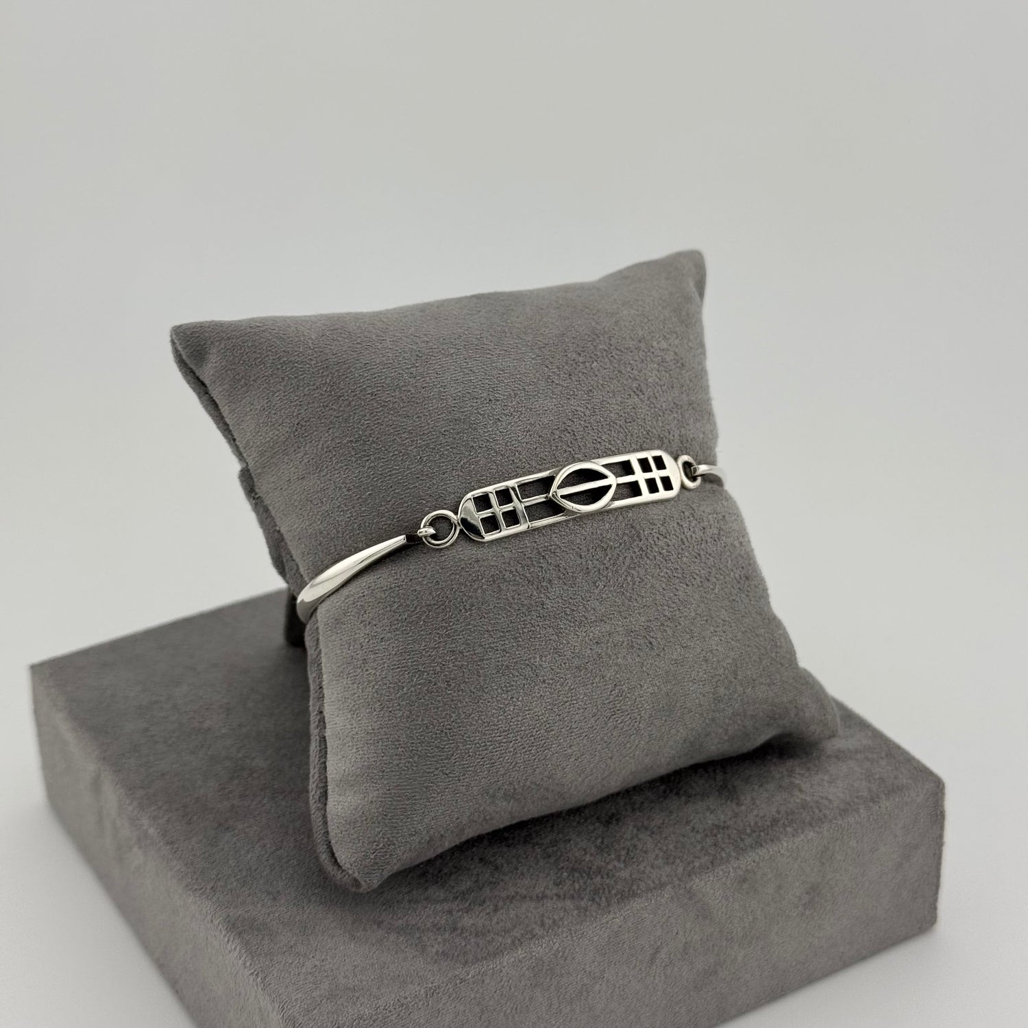 sterling silver kit heath bracelet displayed on a suede grey cushion 