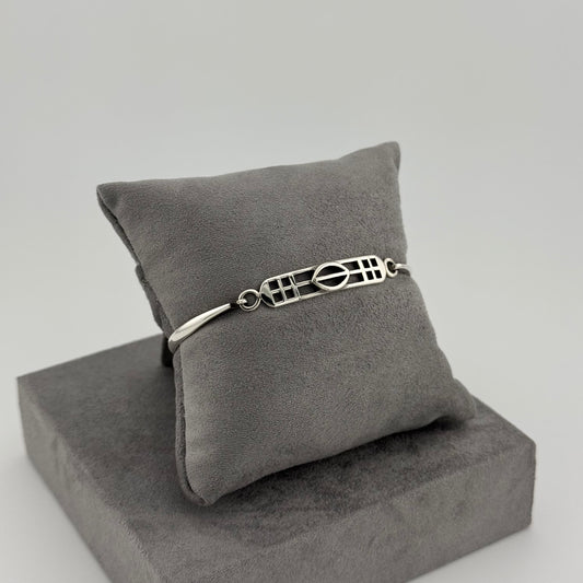 sterling silver kit heath bracelet displayed on a suede grey cushion 