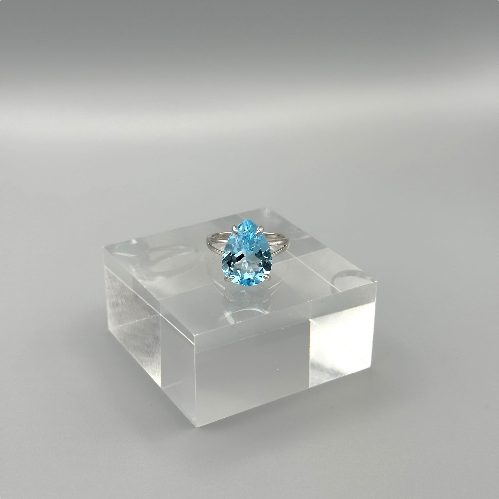 Sterling silver ring with pear-cut aquamarine on acrylic block