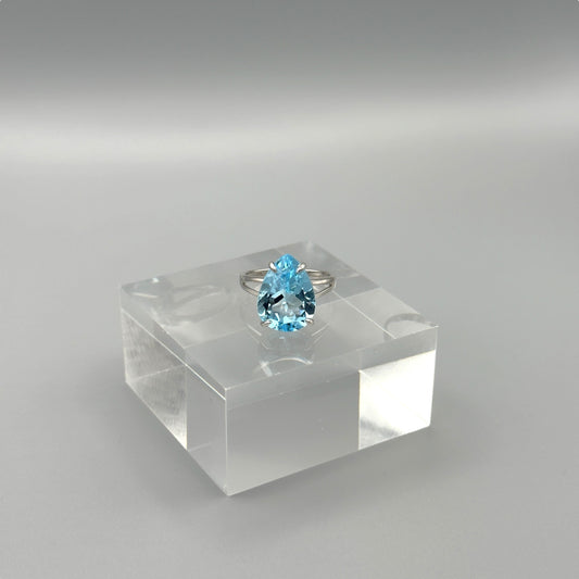 Sterling silver ring with pear-cut aquamarine on acrylic block