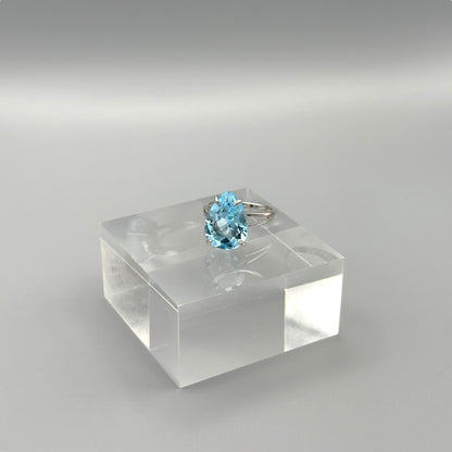 Side view of aquamarine ring on clear display cube
