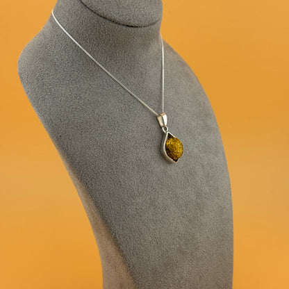 Necklace with a pendant on a mannequin bust against an orange background