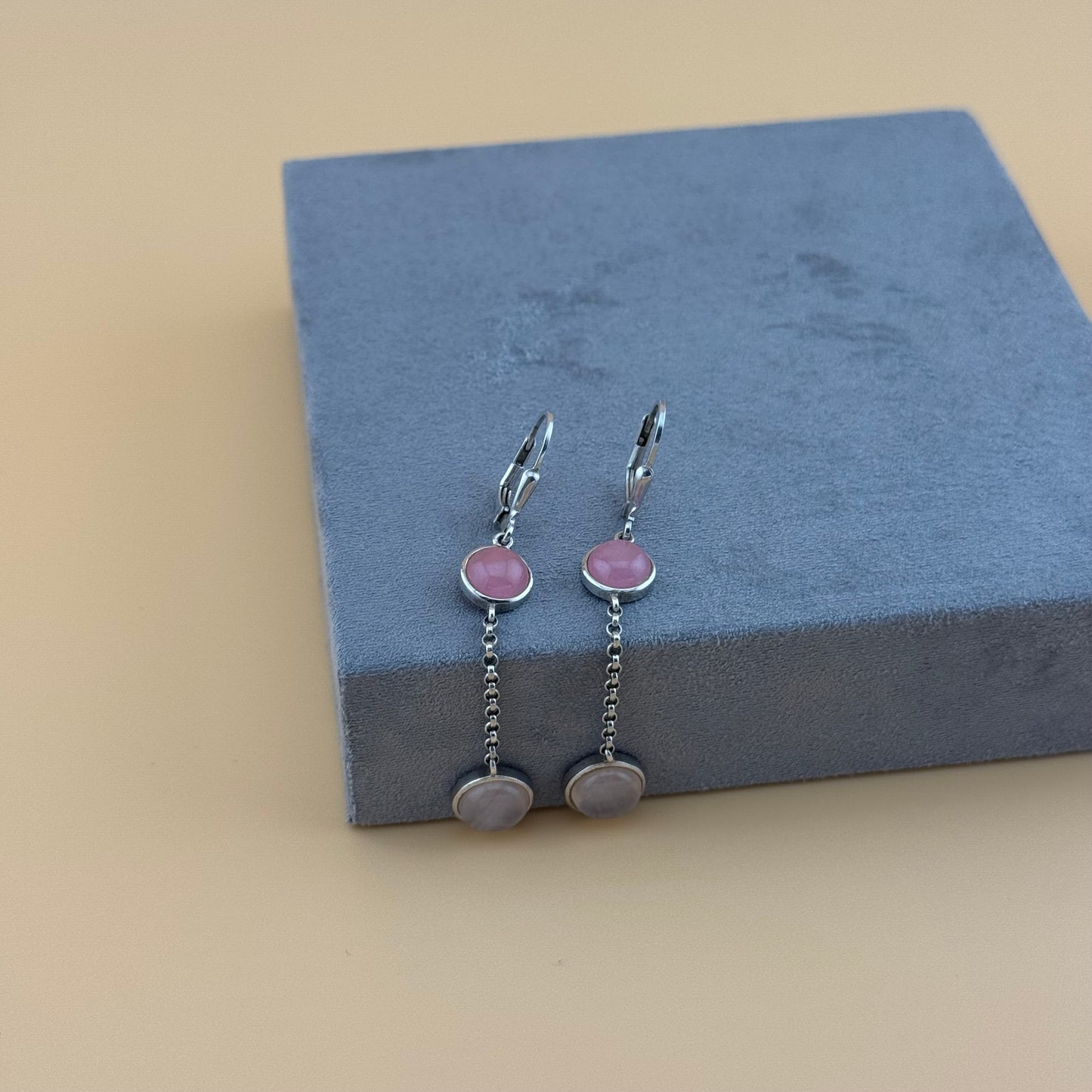Pair of earrings with pink stones on a blue cushion