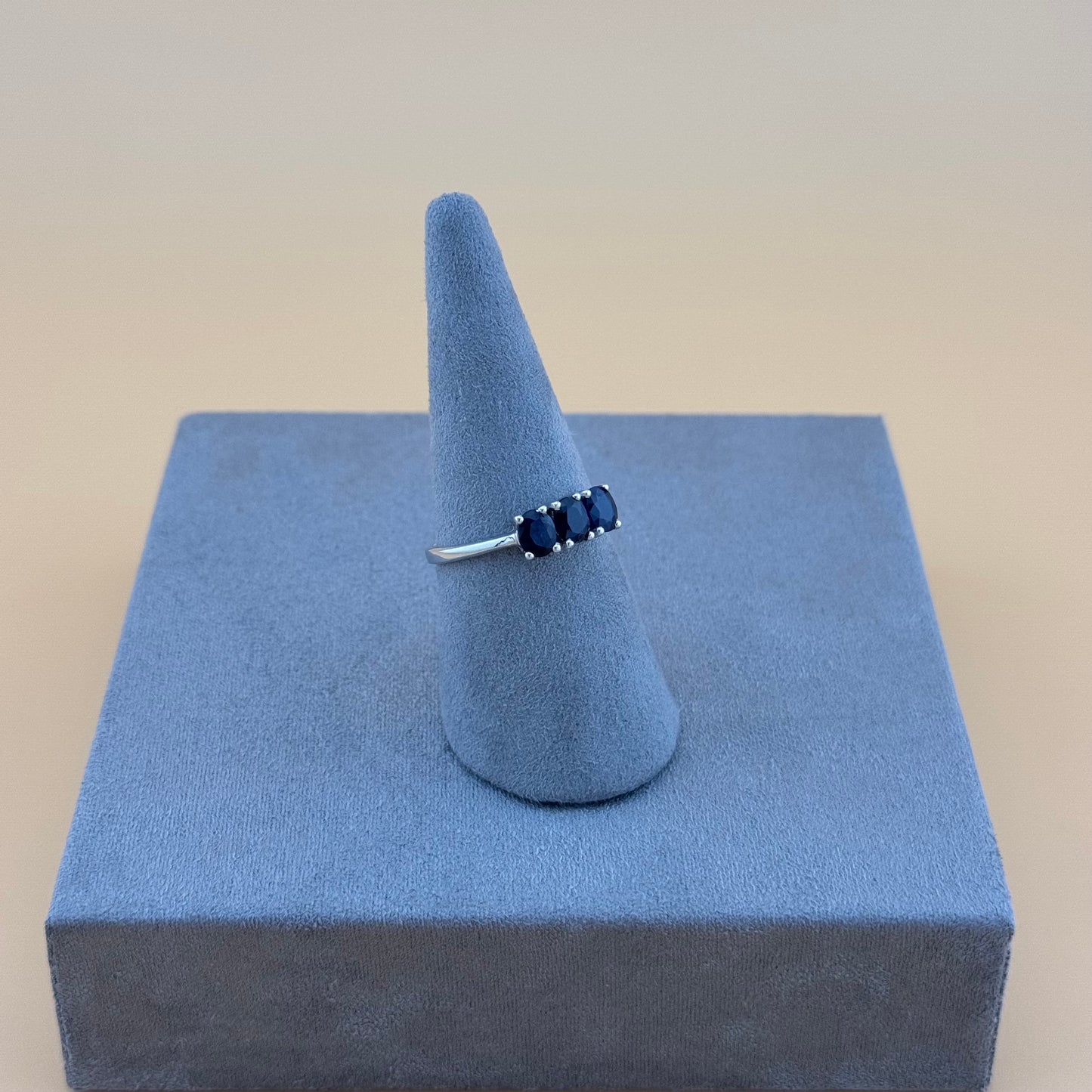 sapphire Ring on a blue stand with a beige background