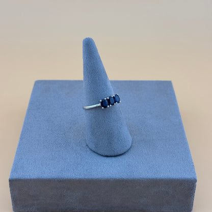 sapphire Ring on a blue stand with a beige background