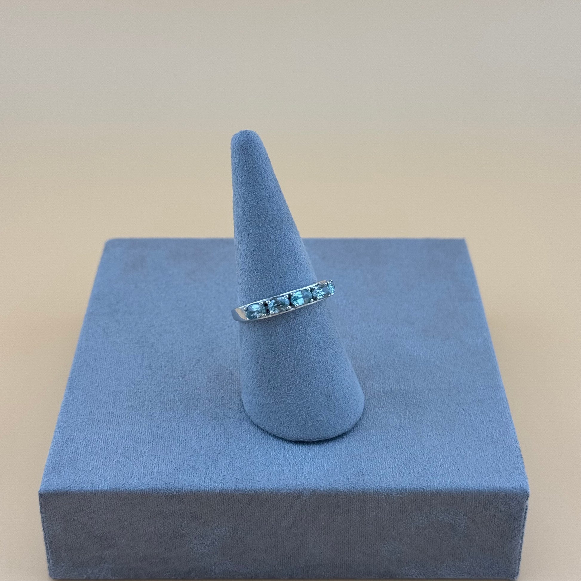 silver aquamarineRing on a blue stand with a beige background