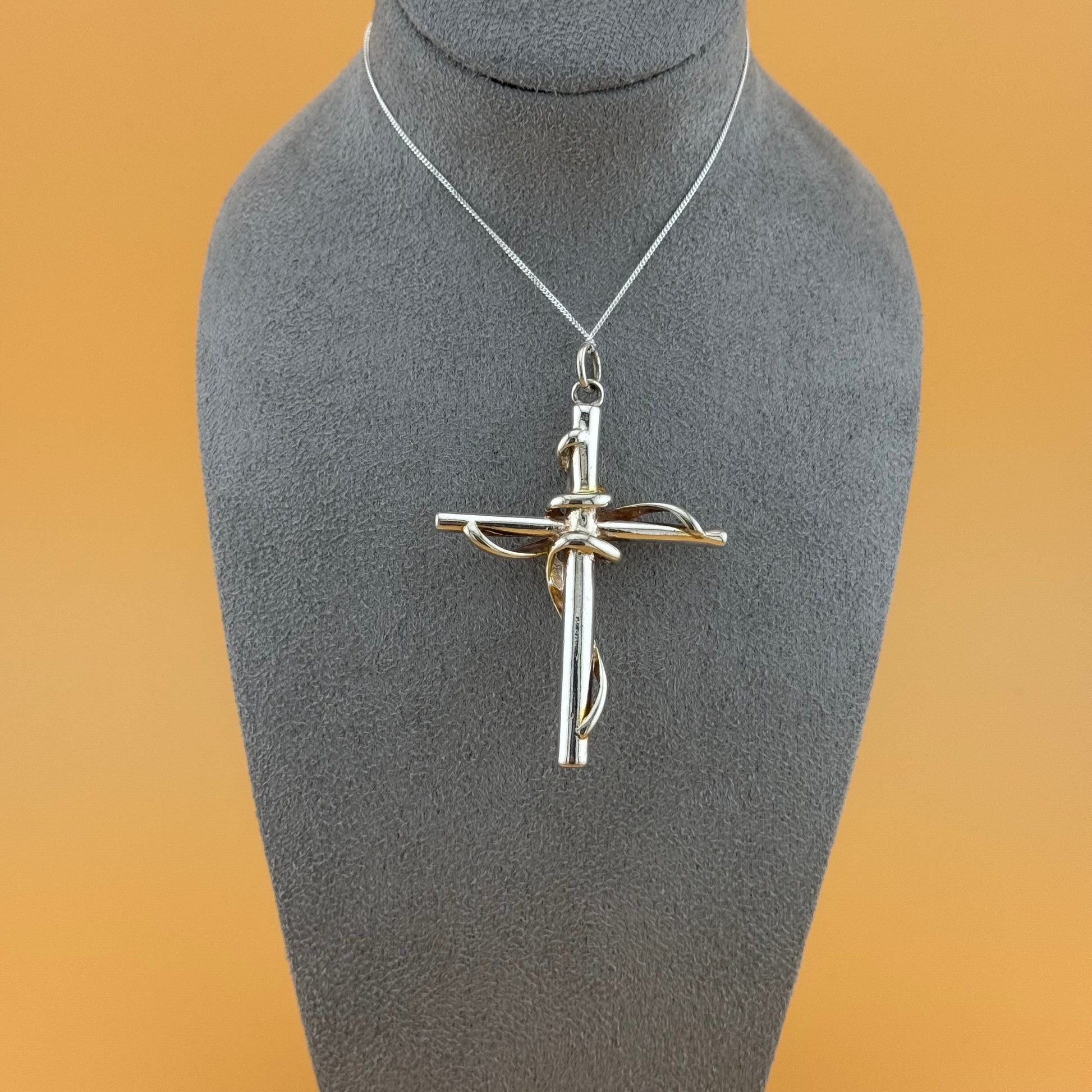 Silver cross pendant on a mannequin bust