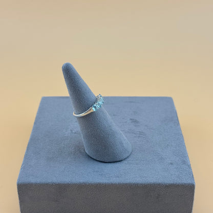 aquamarine Ring on a blue cone-shaped stand against a beige background