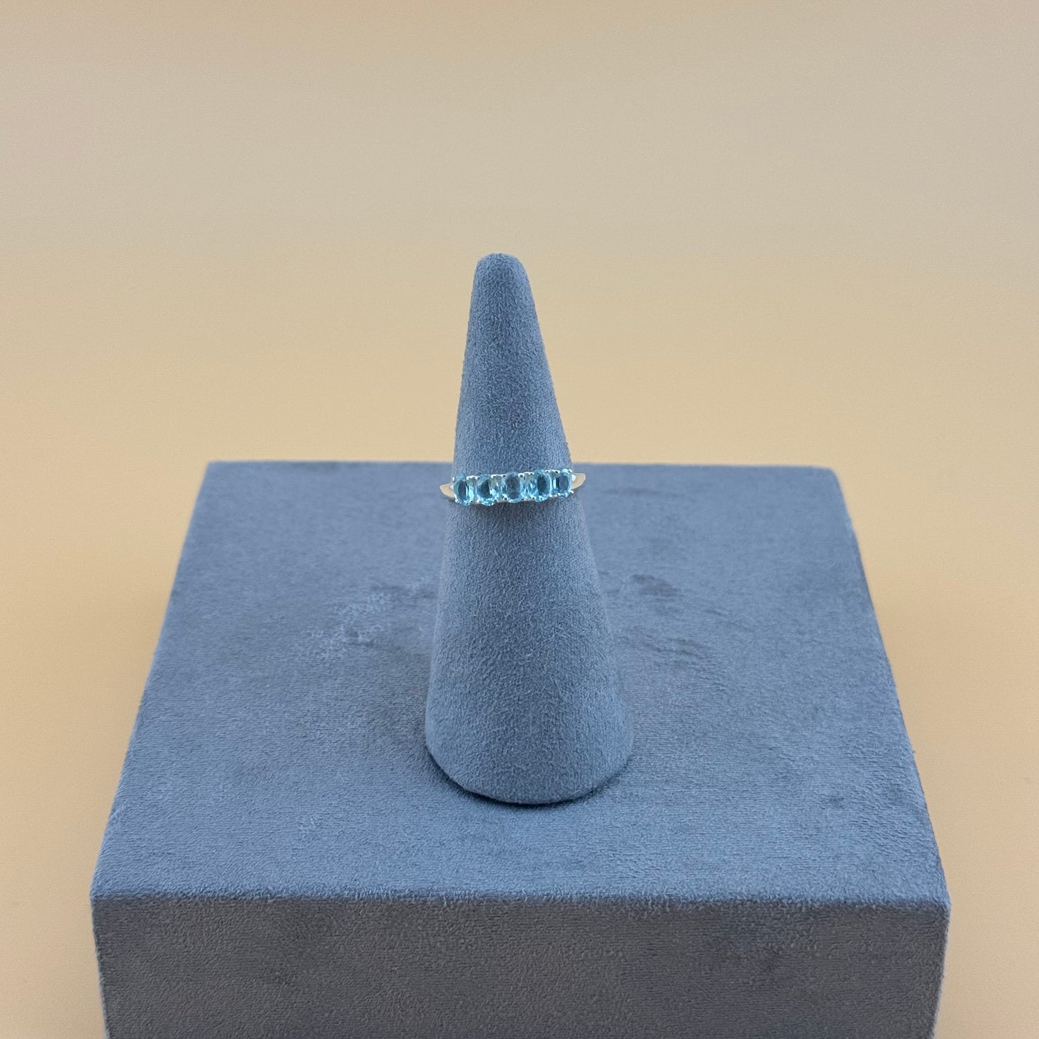 Aquamarine Ring on a blue cone-shaped stand with a beige background