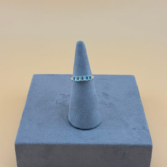 Aquamarine Ring on a blue cone-shaped stand with a beige background