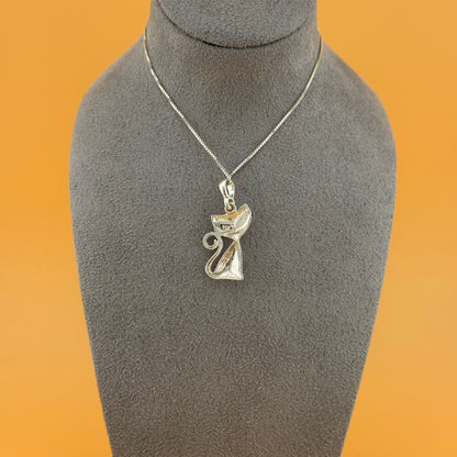Silver pendant necklace on a gray mannequin bust against an orange background