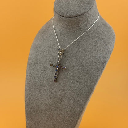 Necklace with a cross pendant on a mannequin bust against an orange background