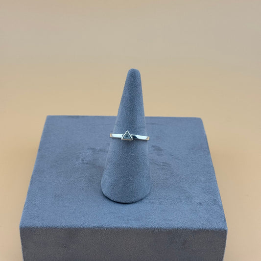 Silver ring on a gray cone-shaped stand against a beige background